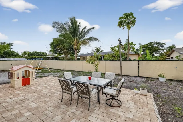a house with a big yard and palm trees