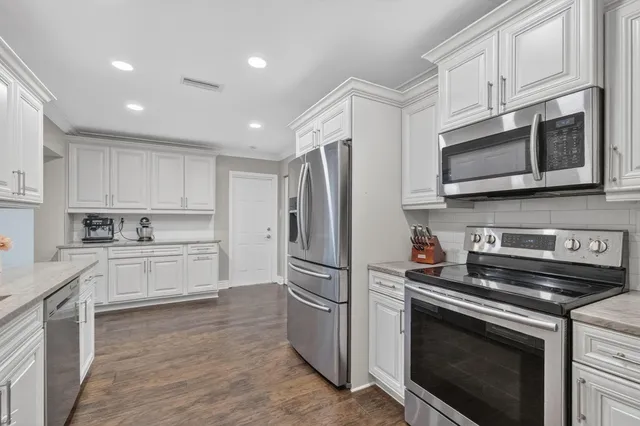 a kitchen with stainless steel appliances granite countertop a stove microwave and cabinets