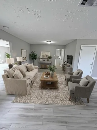 a living room with furniture and a wooden floor