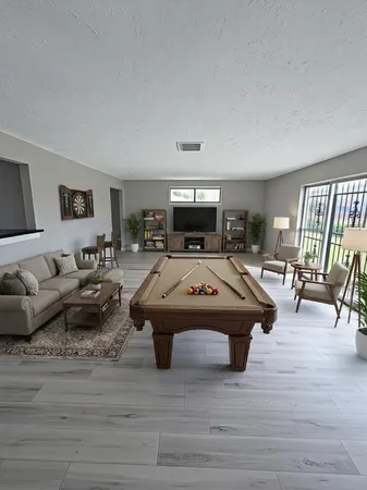 a living room with furniture flat screen tv and a wooden floor
