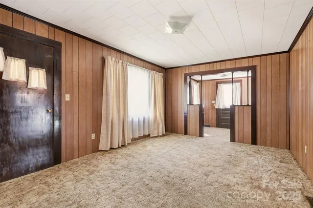 a view of a livingroom with a chandelier fan and windows