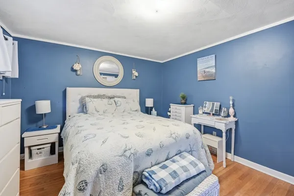 a bedroom with a bed and wooden floor
