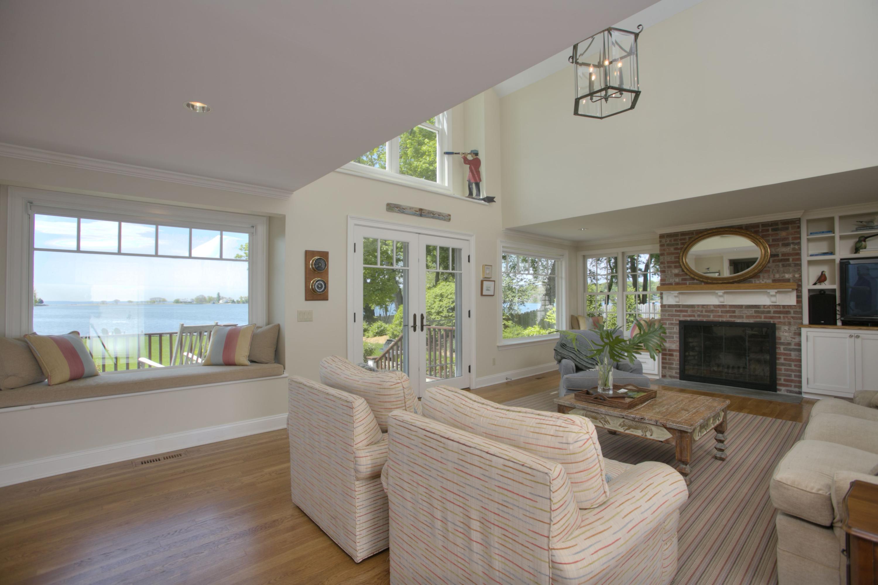 9 Seagate Road Darien, CT 06820 - Photo 11 of 32 a living room with furniture a large window and a fireplace