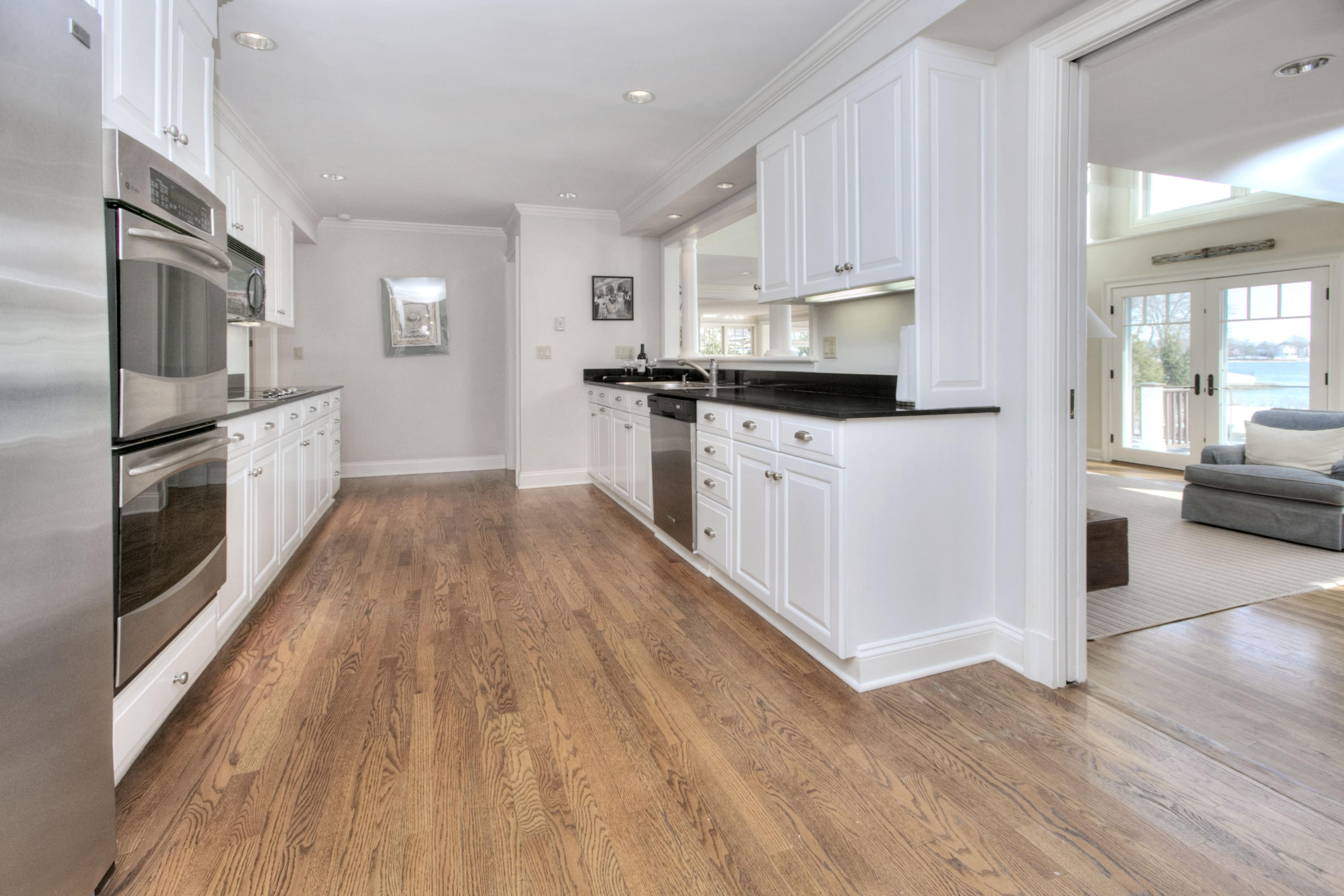 9 Seagate Road Darien, CT 06820 - Photo 14 of 32 a kitchen with stainless steel appliances a stove top oven a sink a refrigerator white cabinets and wooden floor