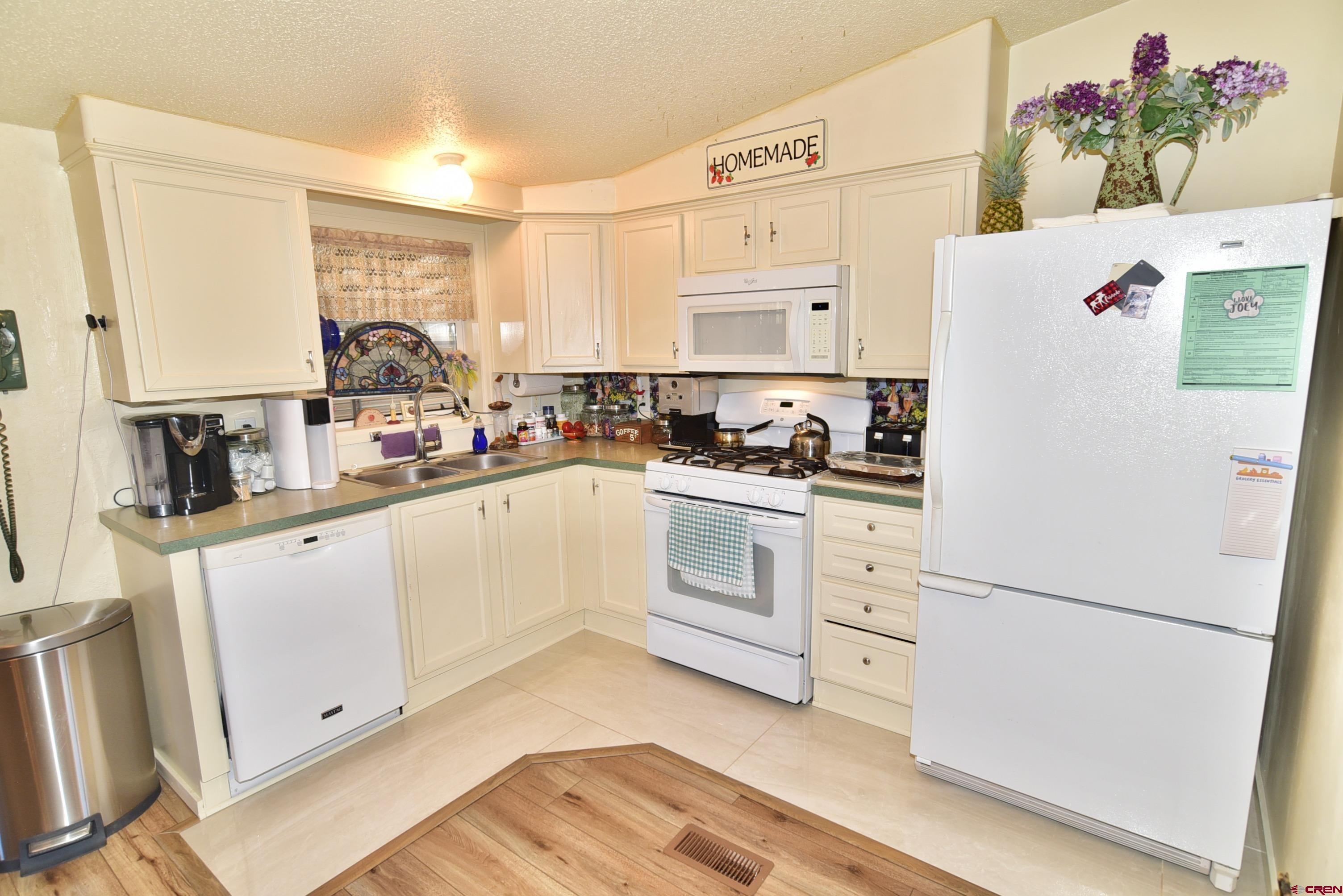 20020 Kenosha Road Austin, CO 81410 - Photo 8 of 40 a kitchen with white cabinets and white appliances