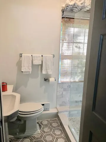 a white toilet sitting next to a bathroom sink