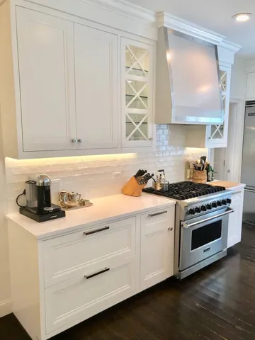 a kitchen with granite countertop a sink cabinets and stainless steel appliances