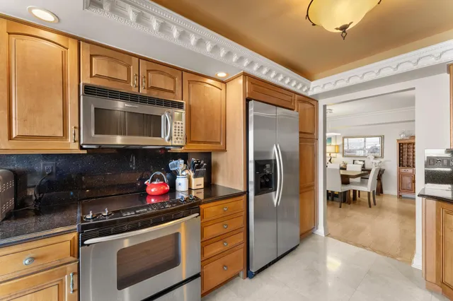 a kitchen with stainless steel appliances granite countertop a stove microwave and refrigerator