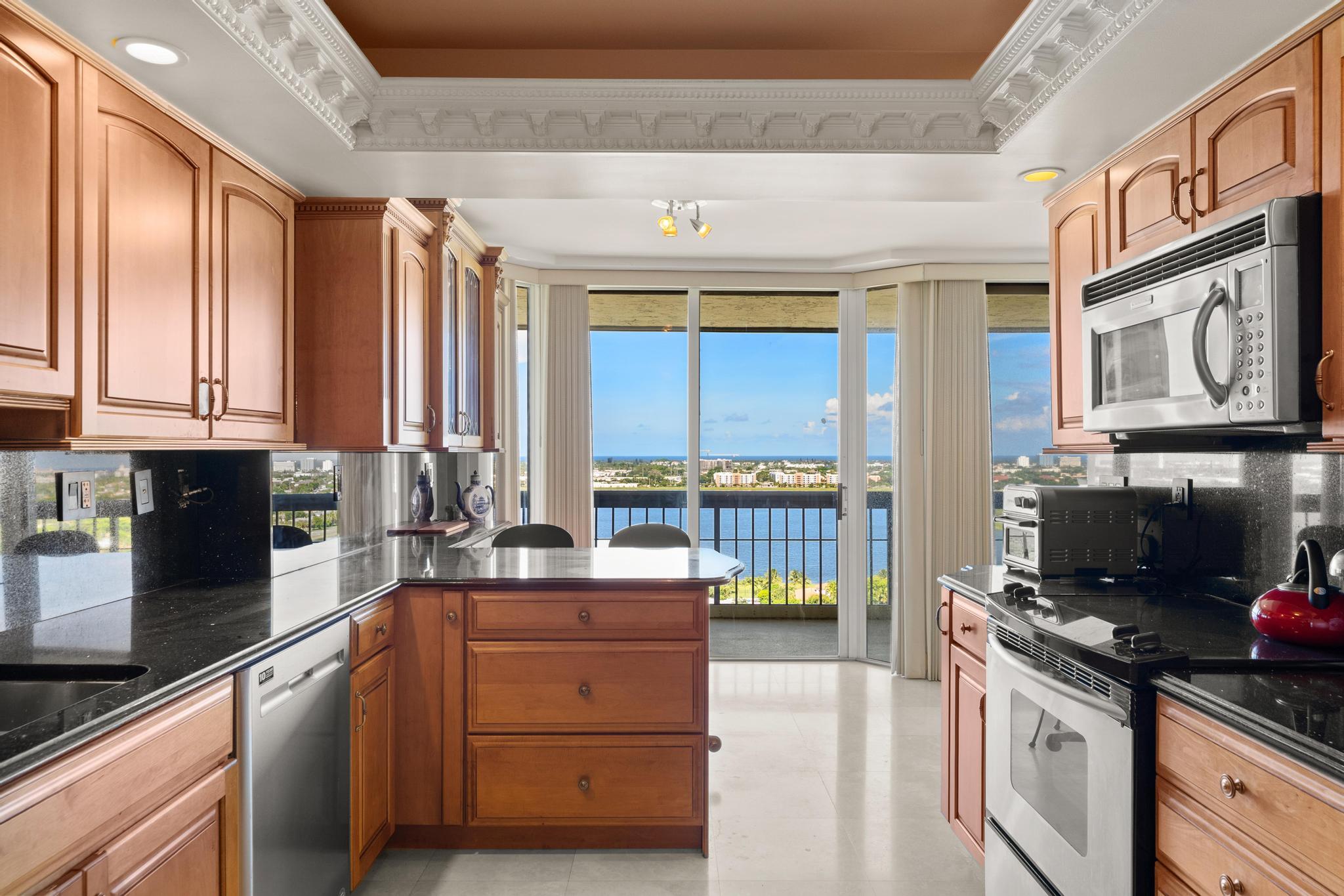 1900 Consulate Place, Unit 2002 West Palm Beach, FL 33401 - Photo 13 of 29 a kitchen with a sink stove and cabinets