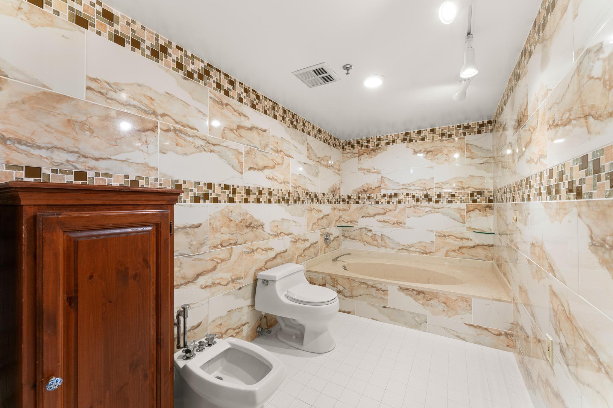 1900 Consulate Place, Unit 2002 West Palm Beach, FL 33401 - Photo 17 of 29 a bathroom with a toilet sink and mirror