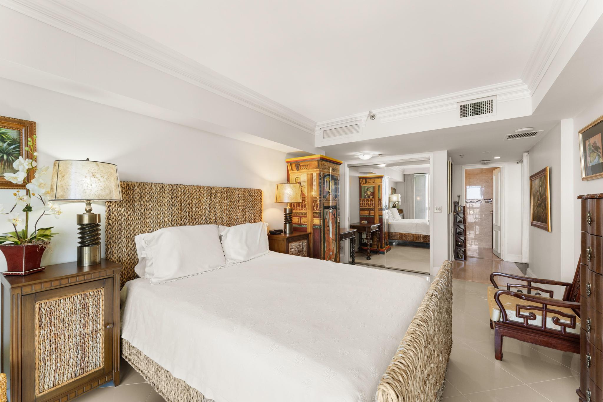 1900 Consulate Place, Unit 2002 West Palm Beach, FL 33401 - Photo 19 of 29 a bed room with a bed and a lamp