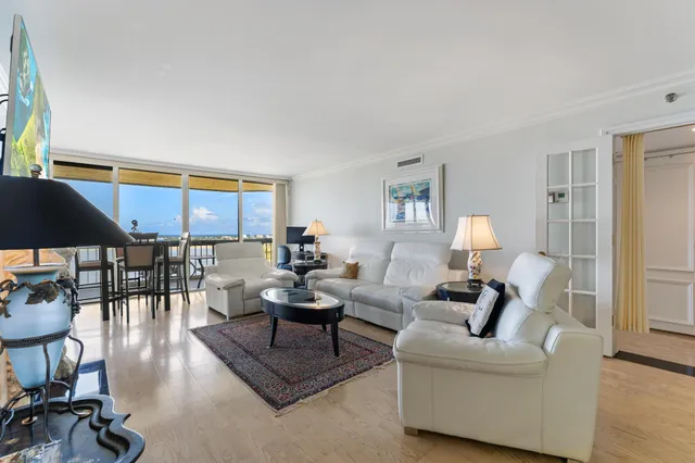 a living room with furniture a rug and a floor to ceiling window