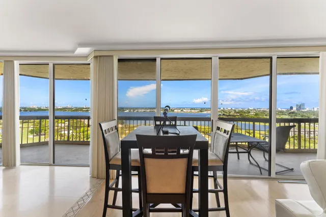 a dining room with furniture large windows and wooden floor