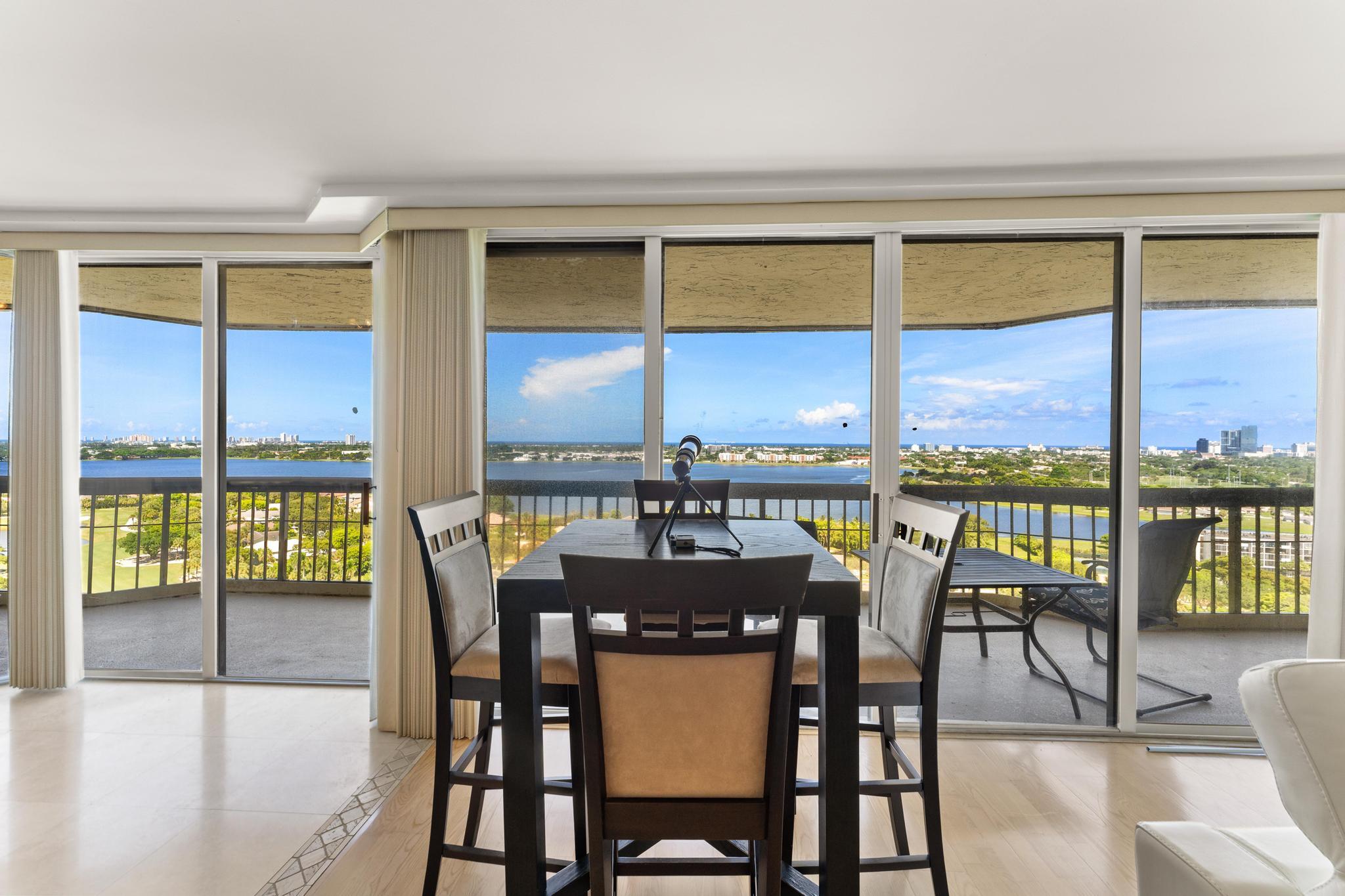 1900 Consulate Place, Unit 2002 West Palm Beach, FL 33401 - Photo 7 of 29 a dining room with furniture large windows and wooden floor