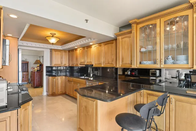 a kitchen with large windows and refrigerator
