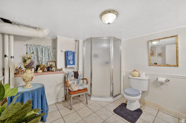 977 23rd Street Ogden, UT 84401 - Photo 21 of 29 Full bath featuring a stall shower, a wainscoted wall, a textured ceiling, and tile patterned floors