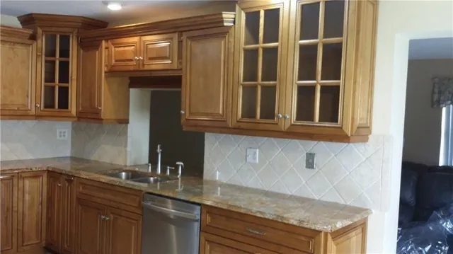 a kitchen with granite countertop a sink and a stove