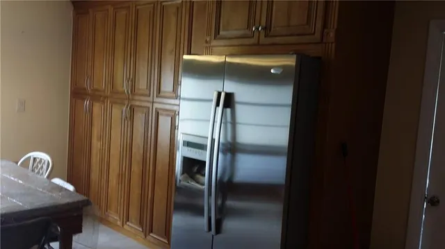 a kitchen with a refrigerator and wooden floor