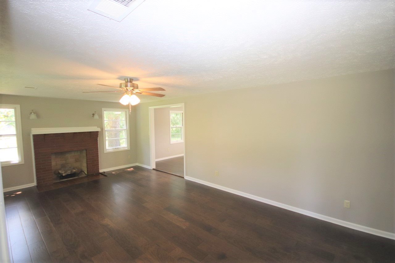 1419 Hurricane Hill Road Ripley, TN 38063 - Photo 12 of 21 an empty room with wooden floor fireplace and window