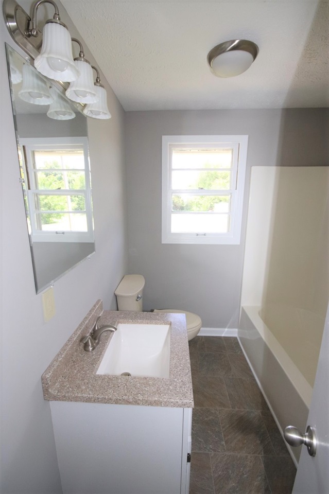 1419 Hurricane Hill Road Ripley, TN 38063 - Photo 13 of 21 a bathroom with a granite countertop sink a toilet and mirror