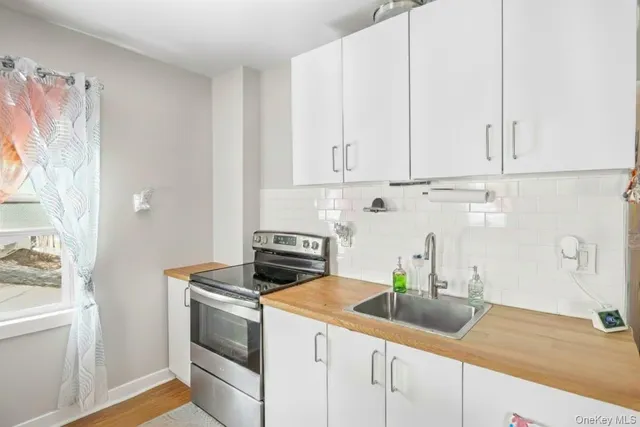a kitchen with stainless steel appliances granite countertop white cabinets a sink and dishwasher