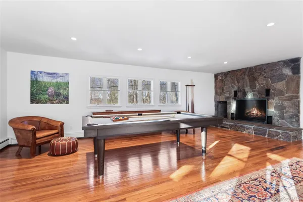 a living room with furniture pool table and a flat screen tv