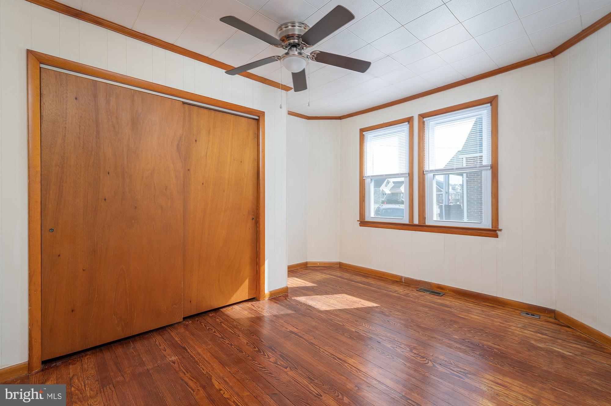 1726 Leslie Road Dundalk, MD 21222 - Photo 16 of 28 an empty room with wooden floor chandelier fan and windows
