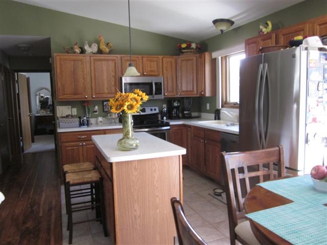 755 Gainsboro Road Lake Summerset, IL 61019 - Photo 2 of 25 a kitchen with stainless steel appliances kitchen island granite countertop a table chairs and a refrigerator