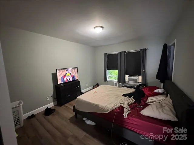 a living room with furniture a flat screen tv and floor to ceiling window
