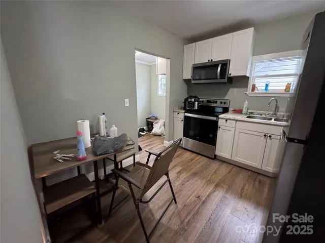 a kitchen with furniture wooden floor and stainless steel appliances
