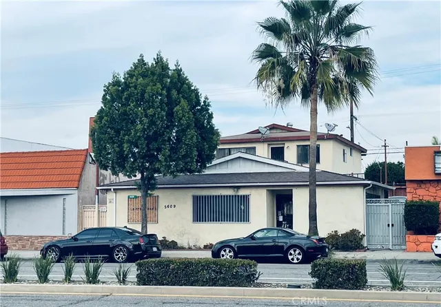 a front view of a house with a garden and parking