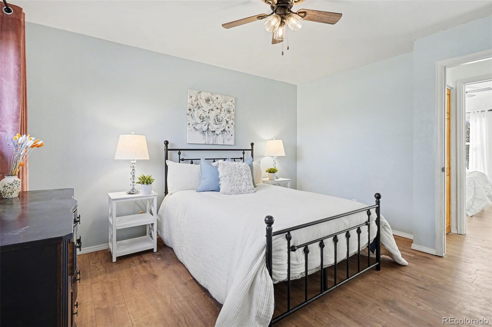 1632 South Rifle Street Aurora, CO 80017 - Photo 13 of 22 a bedroom with a bed and a chandelier