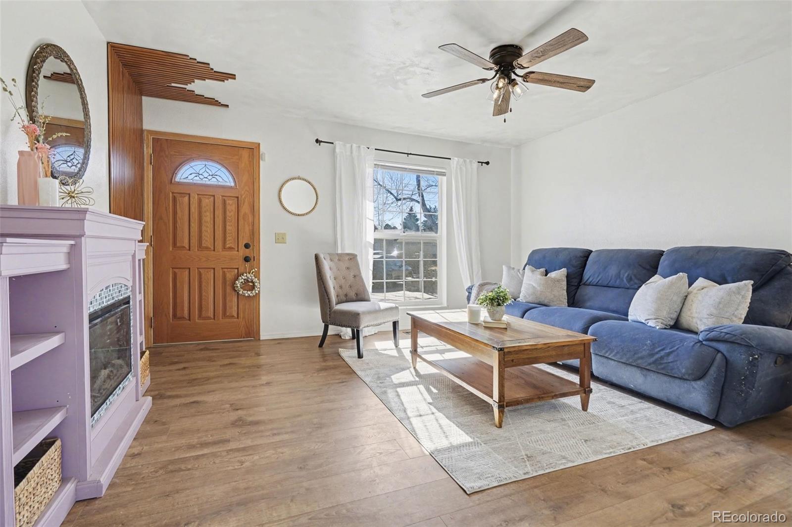 1632 South Rifle Street Aurora, CO 80017 - Photo 5 of 22 a living room with furniture a fireplace and a chandelier