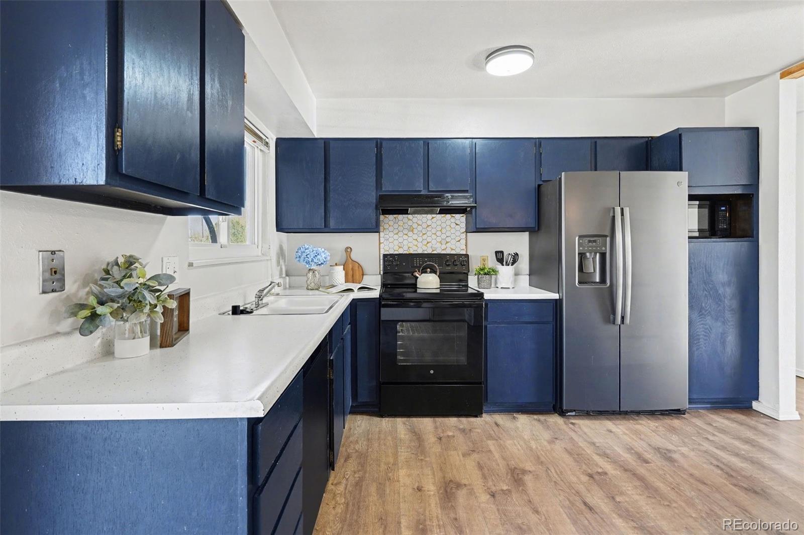 1632 South Rifle Street Aurora, CO 80017 - Photo 9 of 22 a kitchen with a refrigerator sink and wooden cabinets