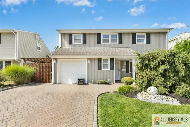 a front view of a house with a yard outdoor seating and garage