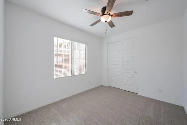 an empty room with a window and a fan