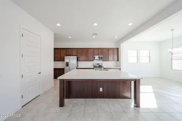 a view of a kitchen with kitchen island a sink wooden floor and window