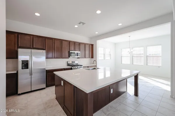 a kitchen with kitchen island granite countertop a sink a counter top space appliances and cabinets