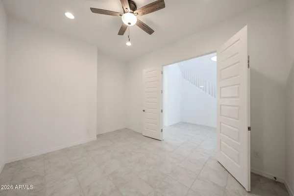 an empty room with closet and a chandelier fan