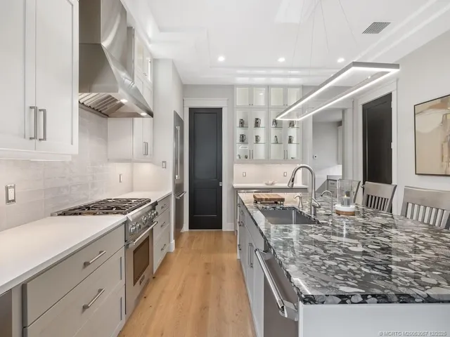 a kitchen with stainless steel appliances granite countertop a sink stove and refrigerator