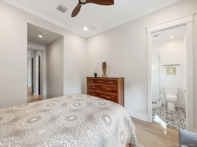 a bedroom with a dresser and a chandelier