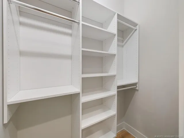 a view of walk in closet with empty racks