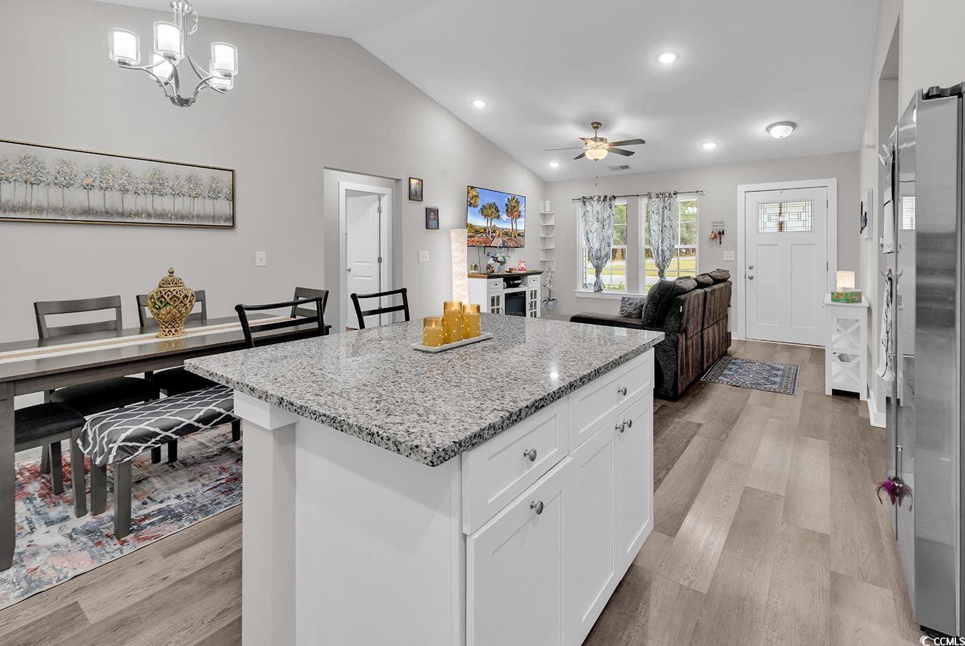 1517 Ackerrose Drive Conway, SC 29527 - Photo 32 of 33 Kitchen with white cabinetry, light stone counters, light wood finished floors, open floor plan, and vaulted ceiling
