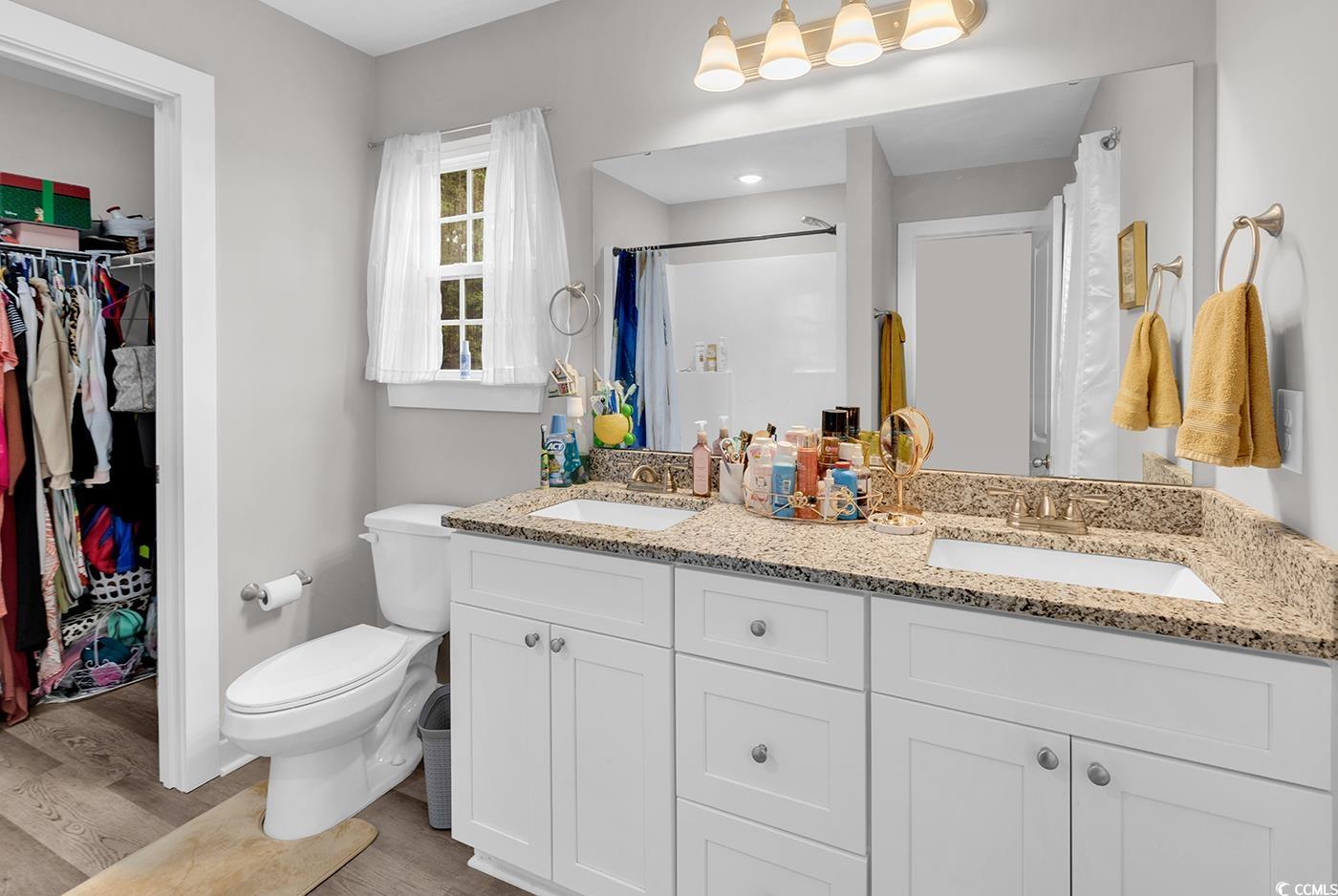 1517 Ackerrose Drive Conway, SC 29527 - Photo 13 of 33 Bathroom featuring a spacious closet, double vanity, light wood-type flooring, and a shower with curtain
