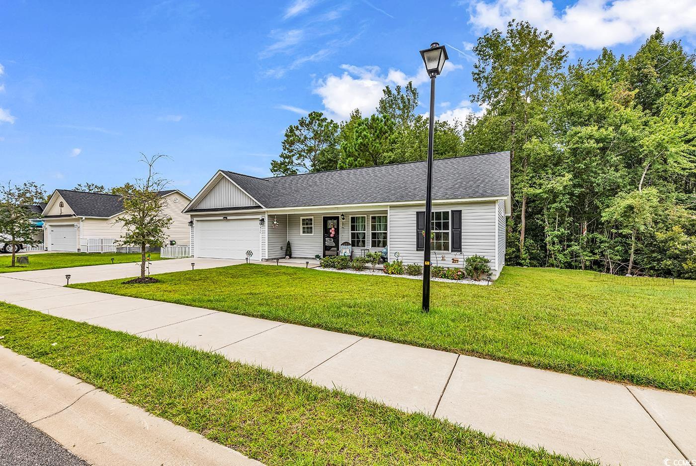 1517 Ackerrose Drive Conway, SC 29527 - Photo 2 of 33 Single story home featuring concrete driveway, board and batten siding, a garage, a front lawn, and roof with shingles