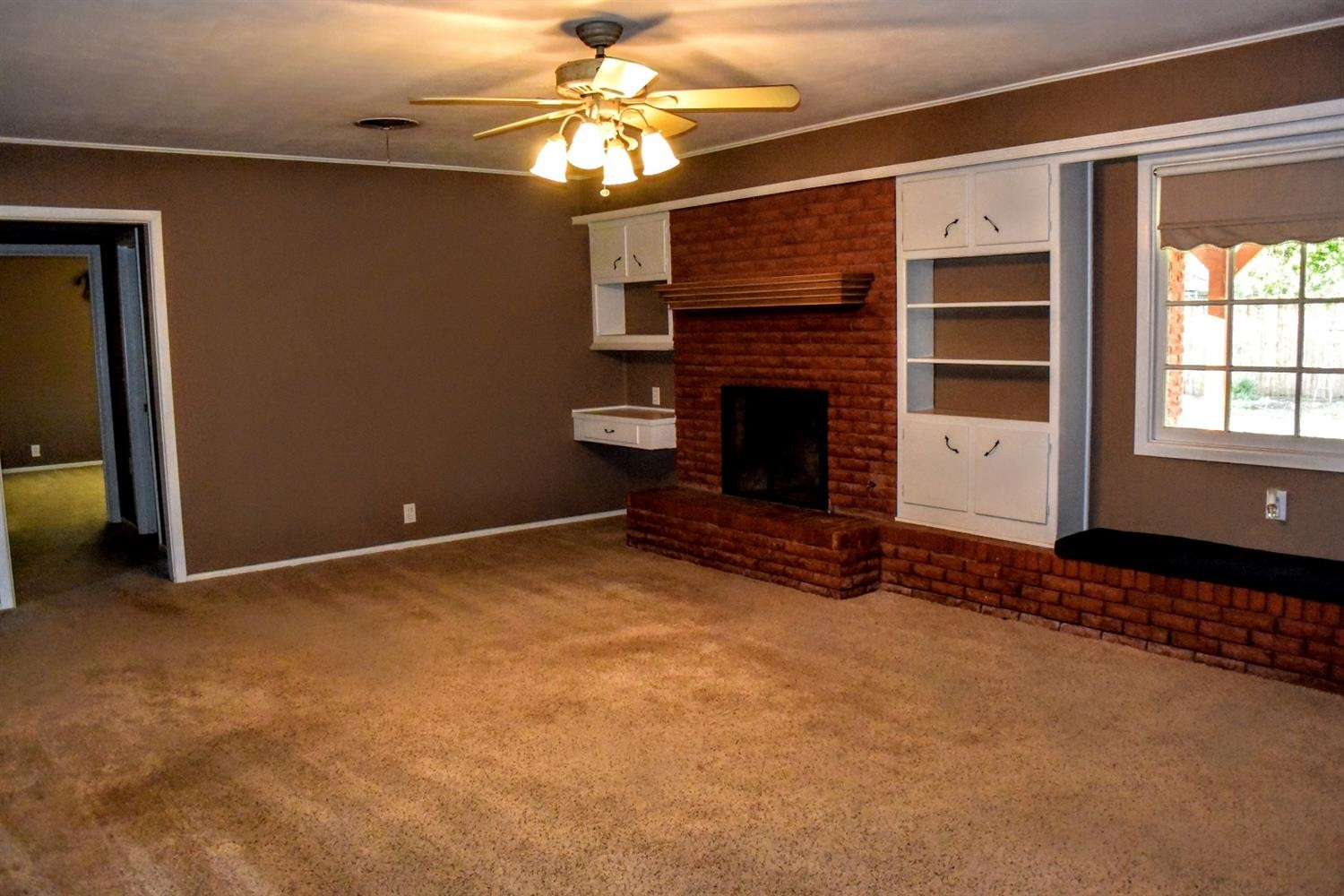 2127 52nd Street Lubbock, TX 79412 - Photo 5 of 10 a view of an empty room with a fireplace and a window