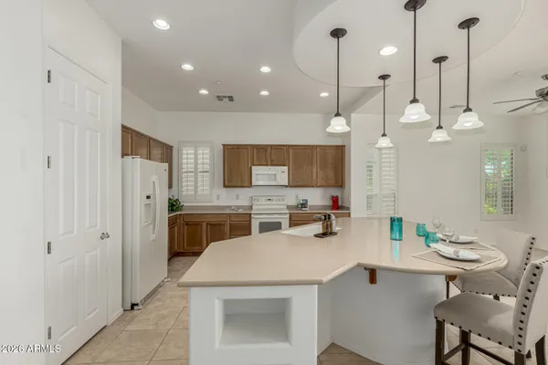 a kitchen that has a sink a stove a dining table and chairs