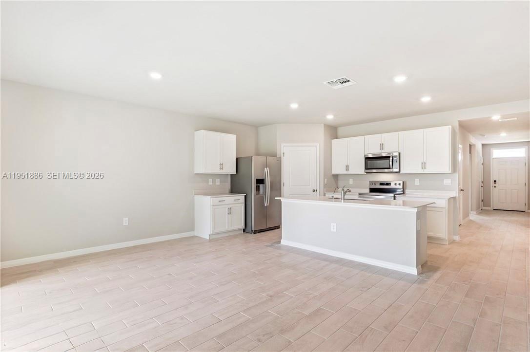 3021 North Lakewood Road LaBelle, FL 33935 - Photo 5 of 13 a view of kitchen with wooden cabinet and refrigerator