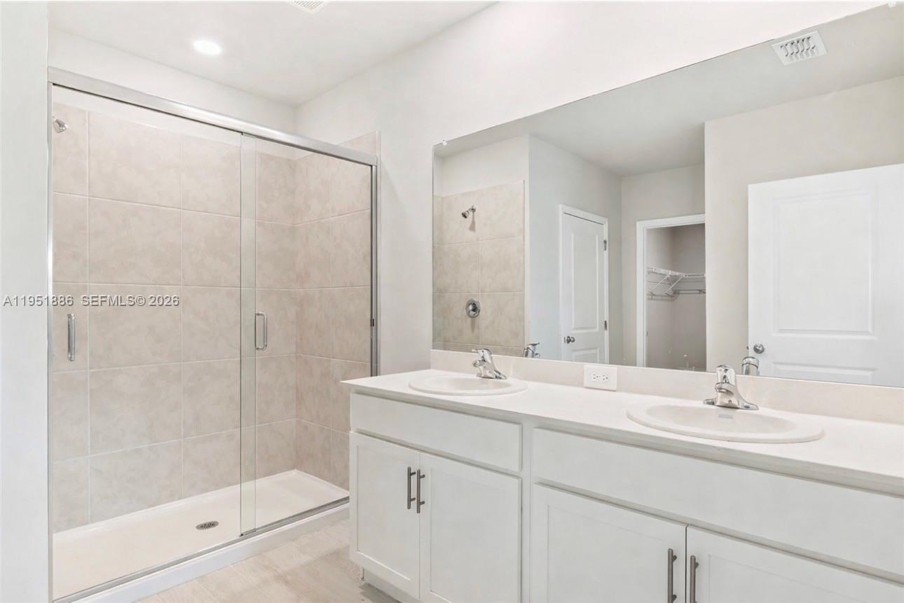 3021 North Lakewood Road LaBelle, FL 33935 - Photo 8 of 13 a bathroom with a shower sink vanity and mirror
