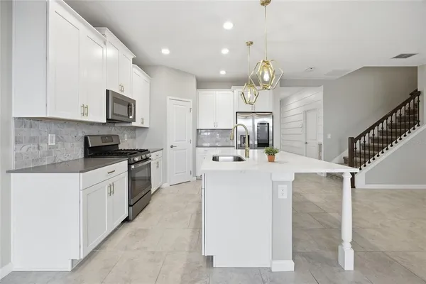 a kitchen with cabinets a sink and a stove top oven with wooden floor
